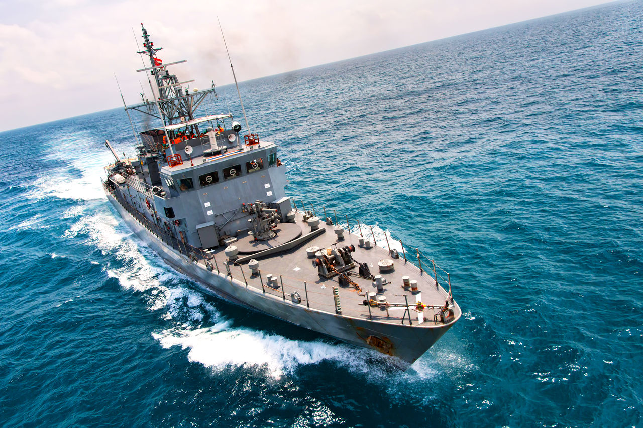 818891074 Grey modern warship sailing in the sea
